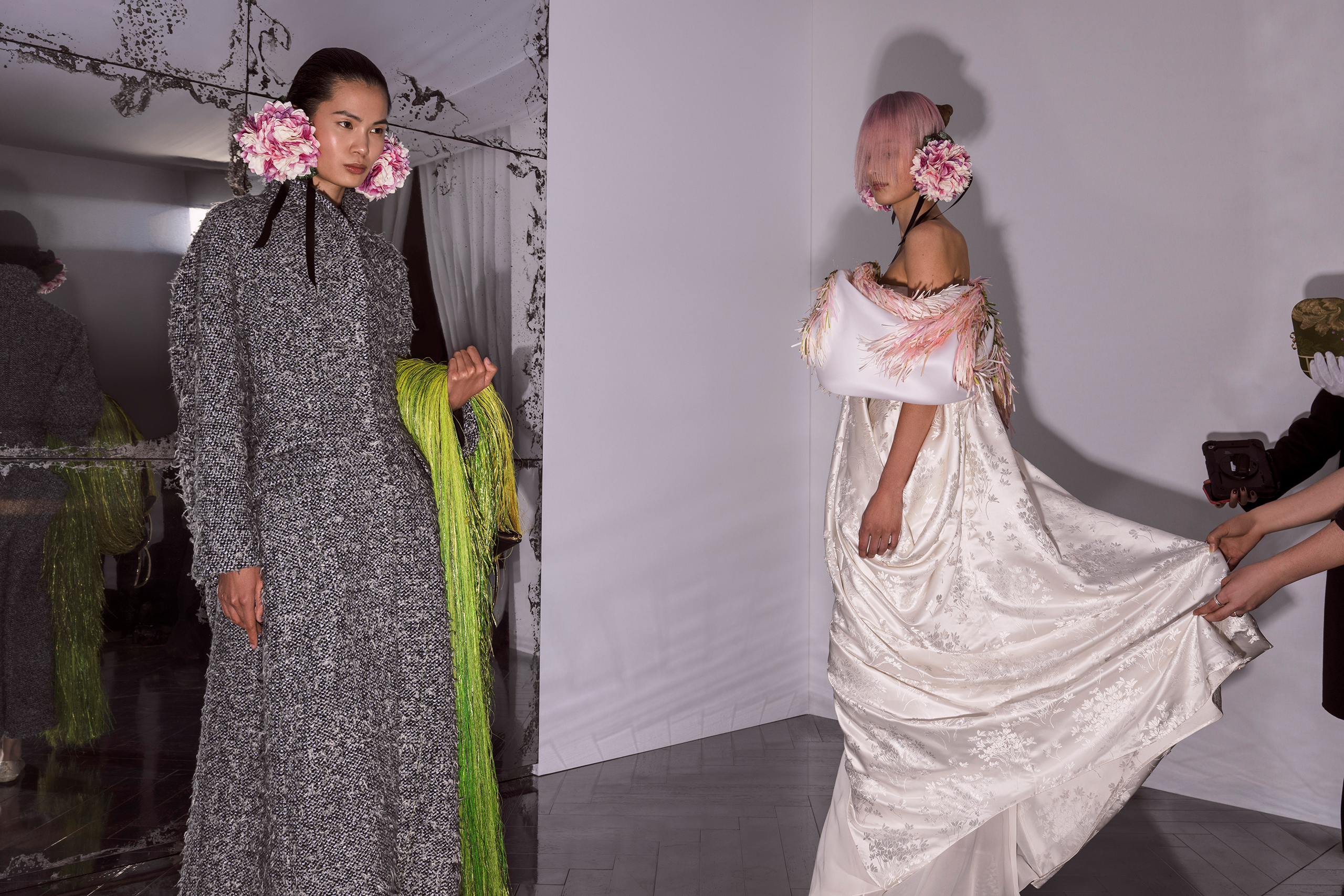RIVIÉRE Long shawl-collar coat in fluffy grey and ecru tweed with open gathers at the back. OMBRÉ Long dress in embroidered ecru silk jacquard; draped large bow enveloping the shoulders with green and pink organza fringes like wild grasses