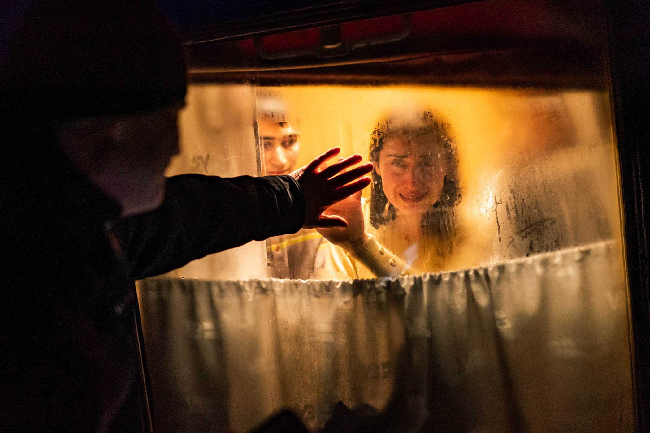 A man says goodbye to his wife and children as they board a train to flee the violence in Odessa